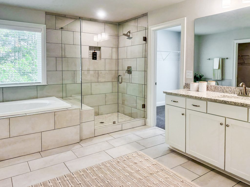View of tub, standing shower, and vanity