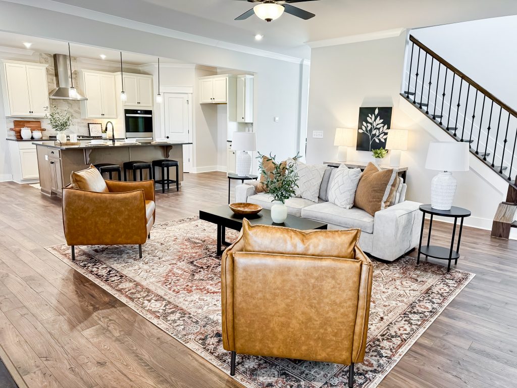 Living room with brown and white furniture and view of kitchen