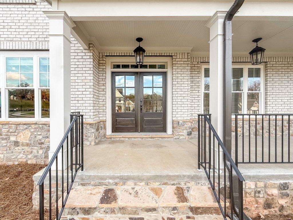 Front porch with brick stairs leading to front door