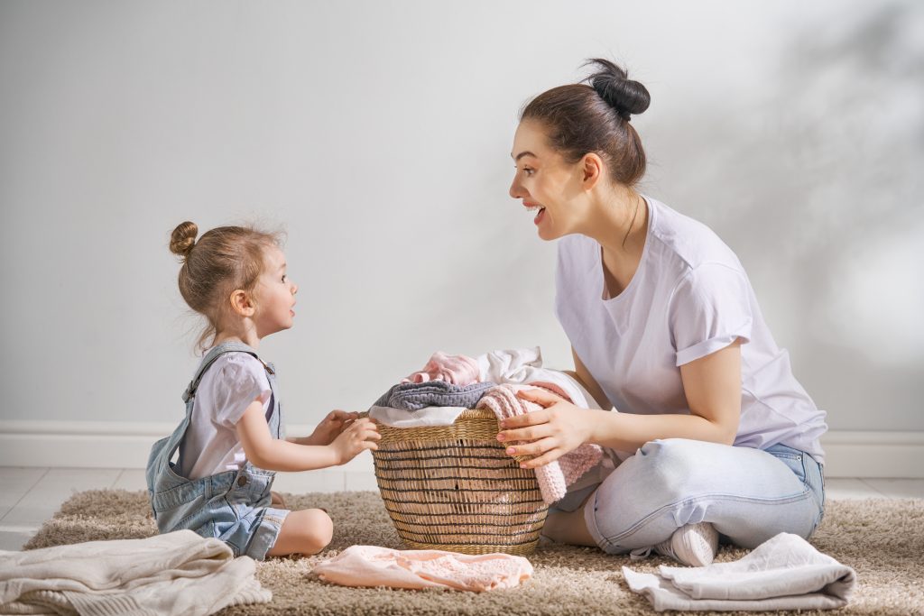 Mother and Daughter laughing and folding laundry