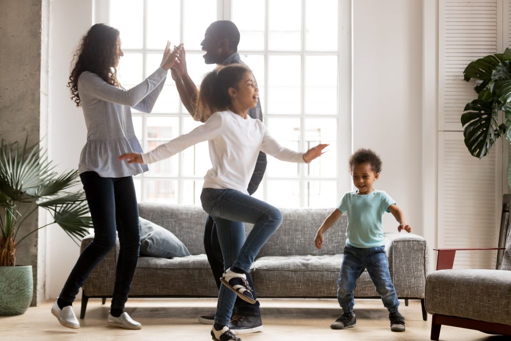 Happy family dancing in living room