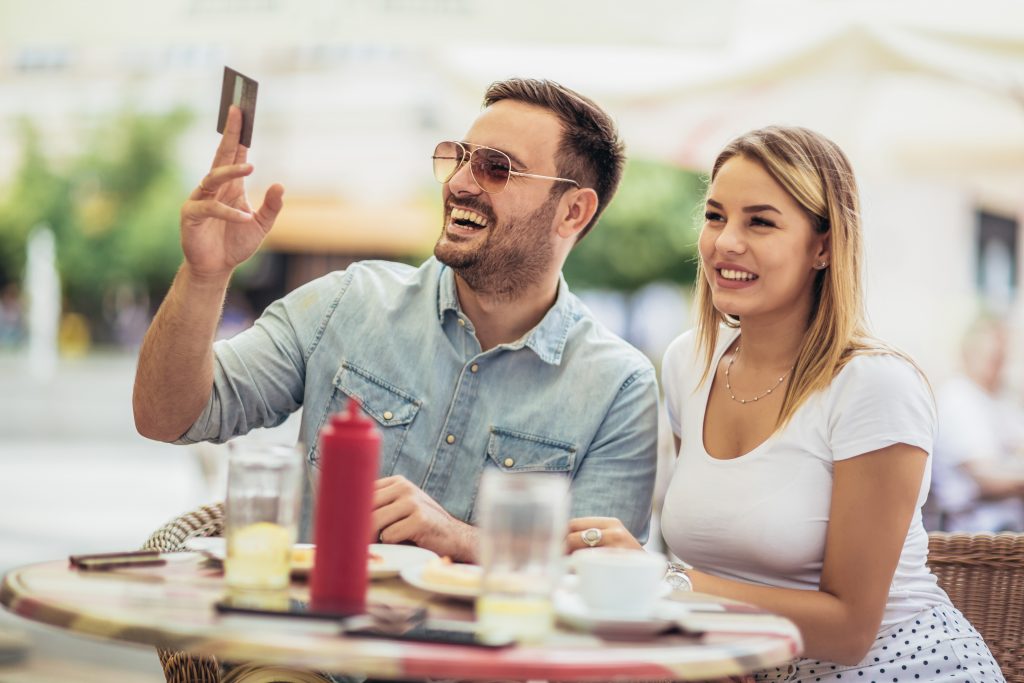 restaurants are reopening in kennesaw - young couple paying the bill (copyright 123rf: Jovan Mandic)