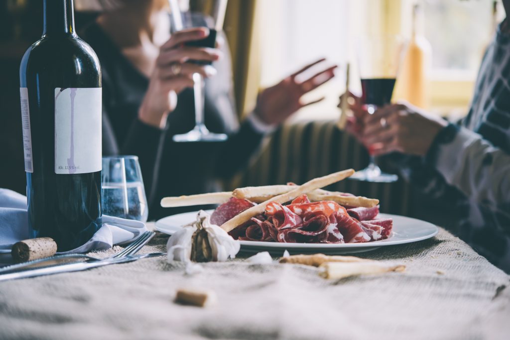 People drinking wine and talking in a restaurant in The Battery Yulia Grigoryeva© Shutterstock