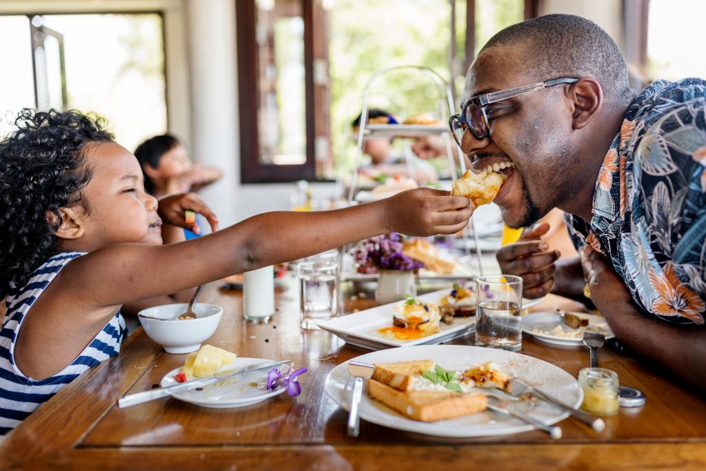 Father and daughter eating breakfast