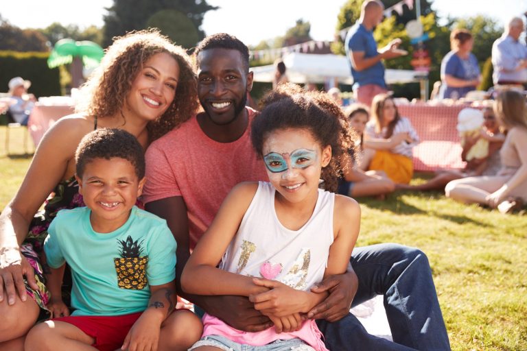 Young family at an outdoor event and daughter has face painted ©Monkey Business Images