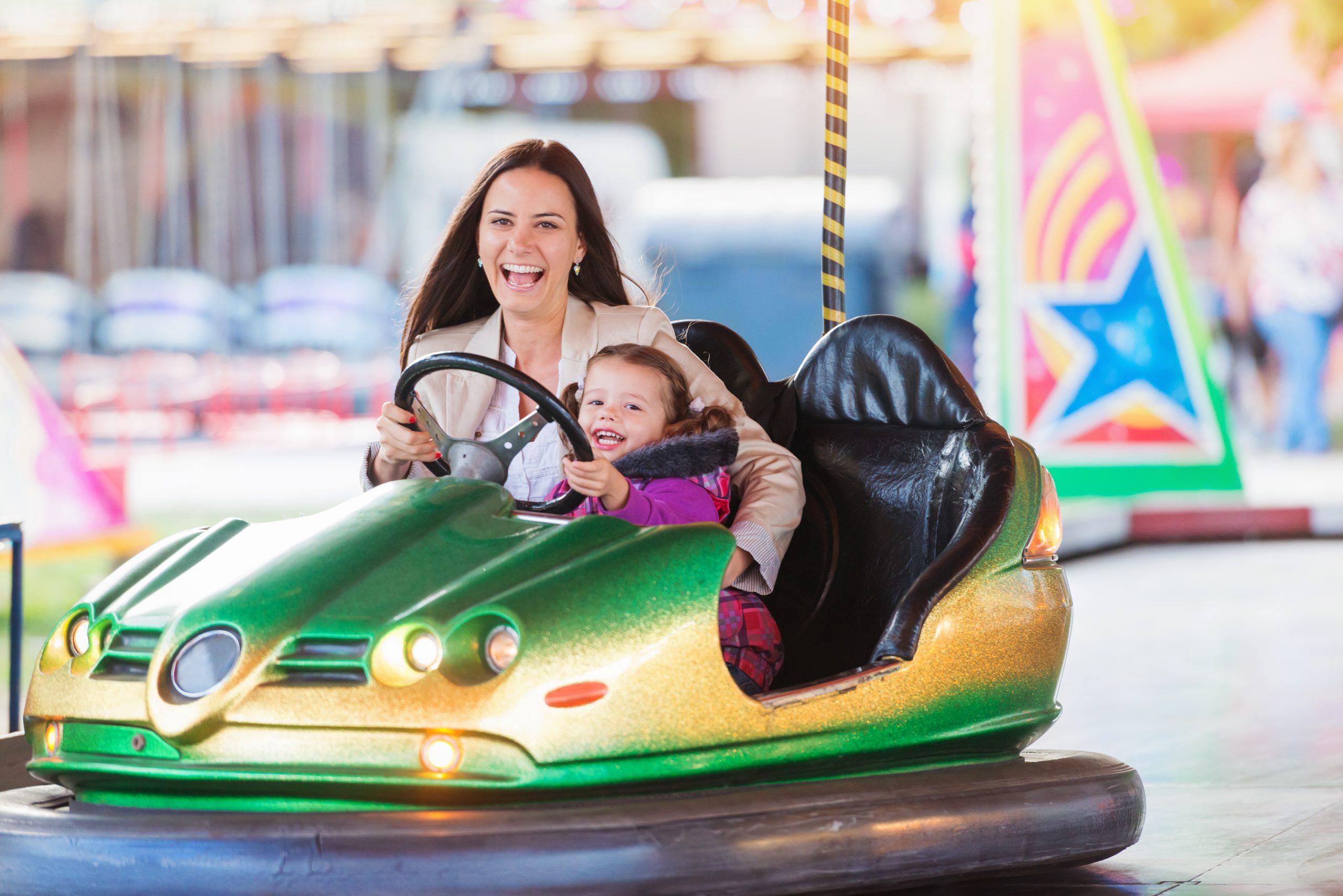 Mom and daughter ride bumper cars at the fair ©Ground Picture