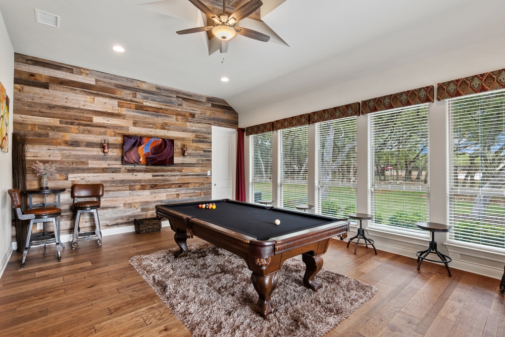 A pool table in a flex space room with big windows ©Allison J. Hahn