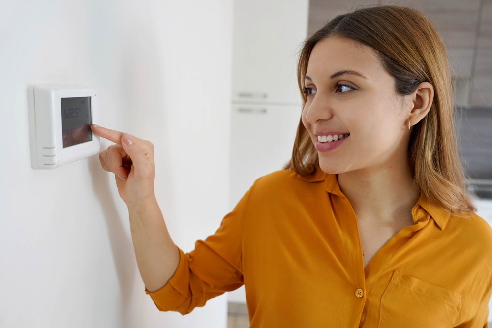 Woman Adjusting Digital Thermostat ©Zigres