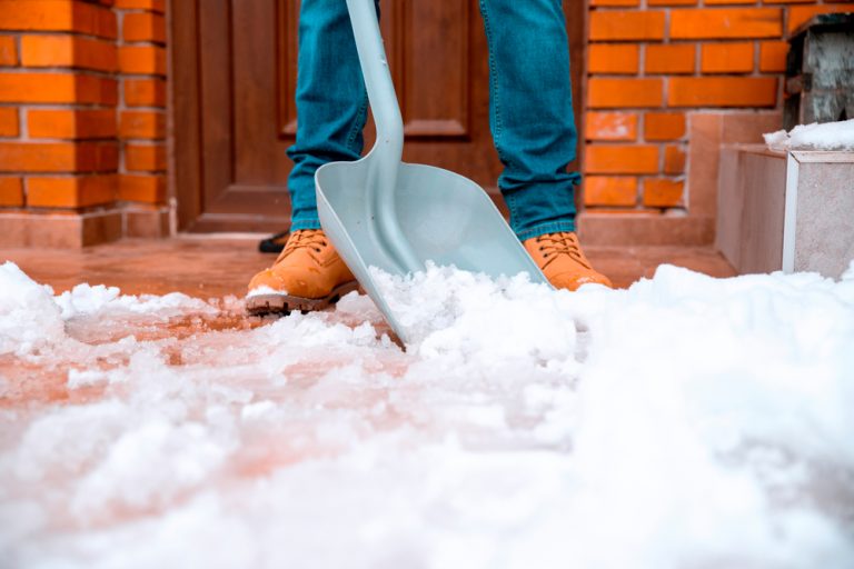 Homeowner shoveling snow off of front porch ©Pearl PhotoPix