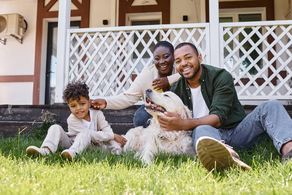 African American family with fluffy dog outside enjoying time ©LightField Studios 