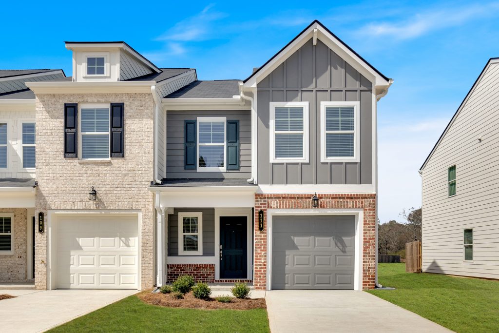 a grey townhouse with red brick and a gray garage 
