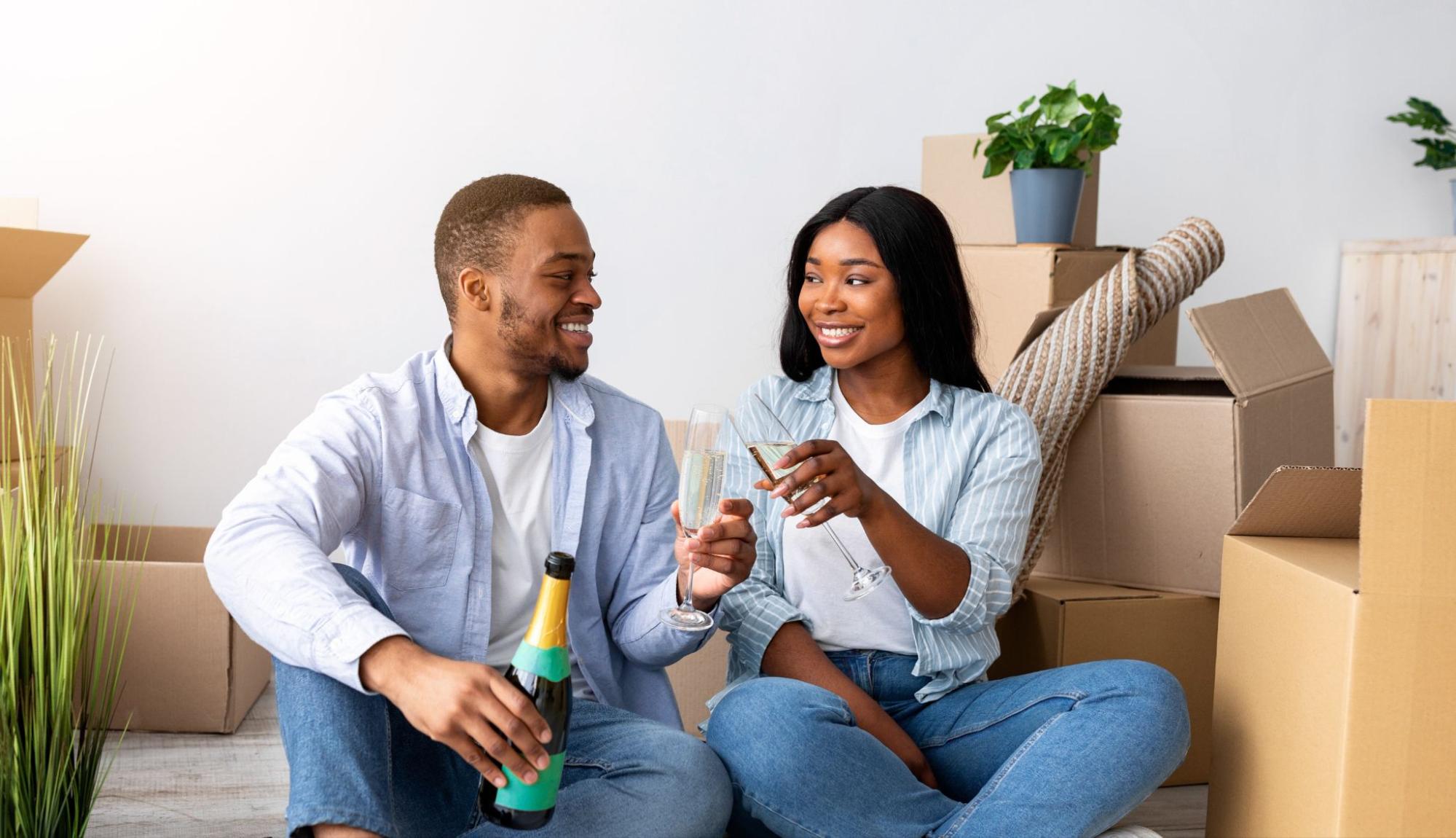 Happy couple celebrating move-in day with champagne in their new Kerley Family Home. ©Prostock-studio
