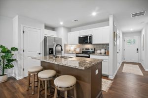 Modern kitchen with granite island in a Silver Leaf townhome in Dawsonville, GA. 