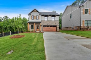 Modern farmhouse style single family home with brick and grey siding at Meadow Pines in Dallas, GA.